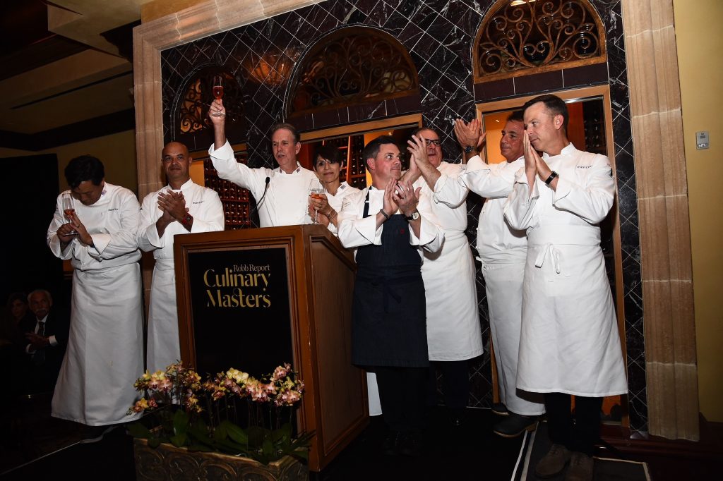 Featured chefs at Robb Report's Culinary Masters gather at The Gala Dinner podium at Addison Restaurant, where the evening saw $200k in proceeds generated for the mentor BKB Foundation.