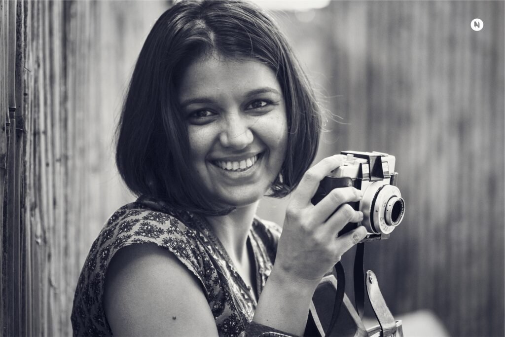 Pretty female photographer smiling with camera