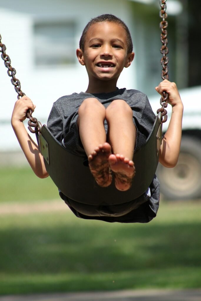 Young boy smiling on a swing