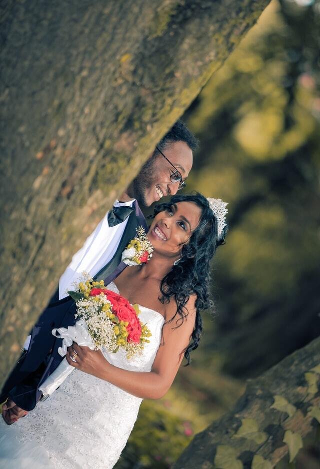 Bride and Groom behind a tree