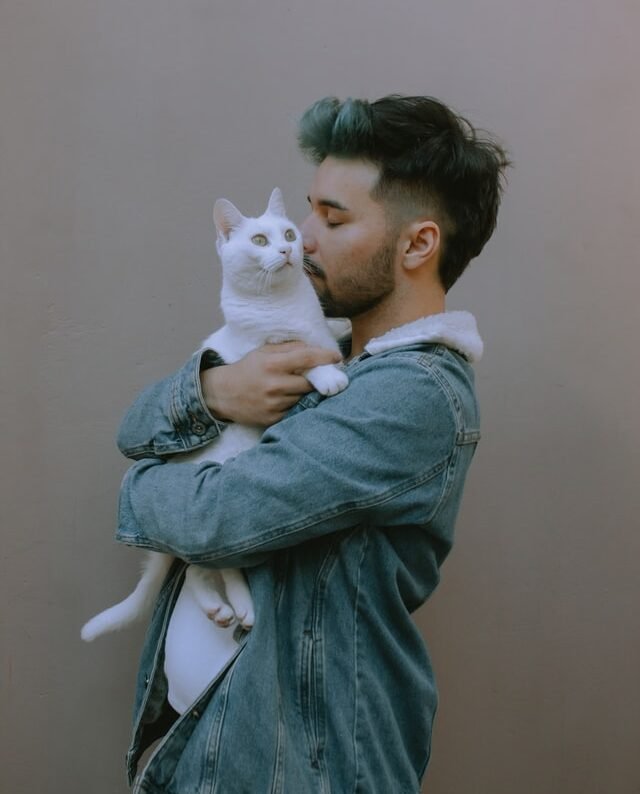 man hugging a cat