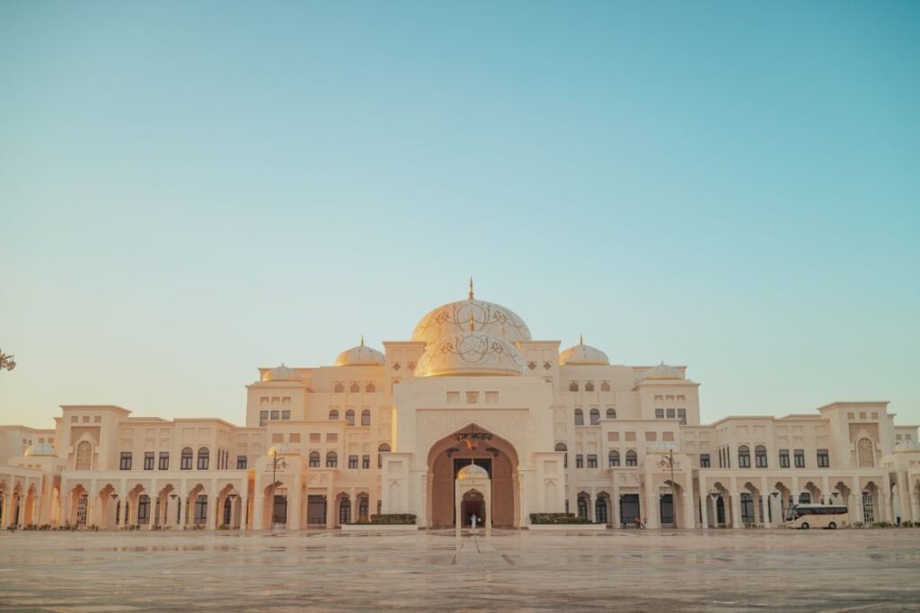 A front shot of the Qasr Al Watan Palace as the sun sets in the background. 