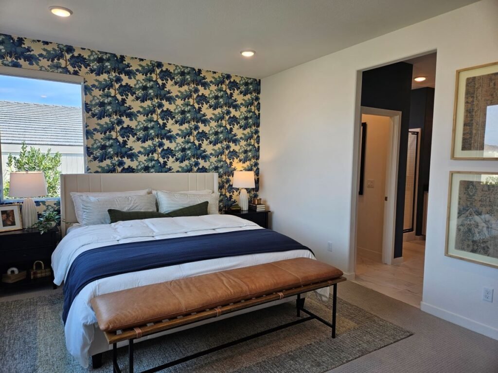 Bedroom with navy blue and white wallpaper on wall behind bed.